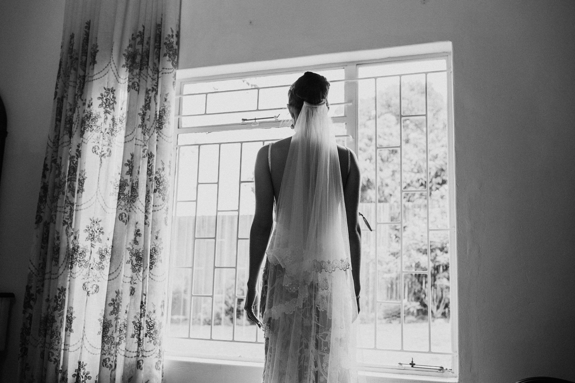 BRIDE LOOKING OUT OF THE WINDOW